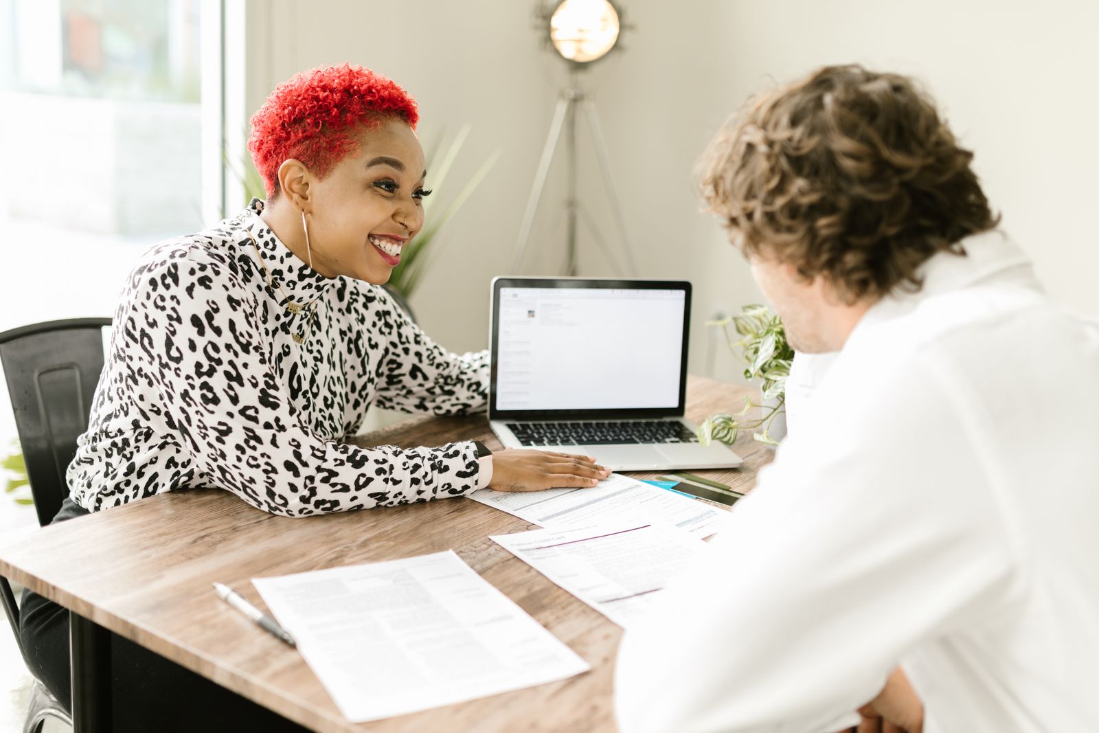 A smiling client and a preparer going over a return on a laptop at a table