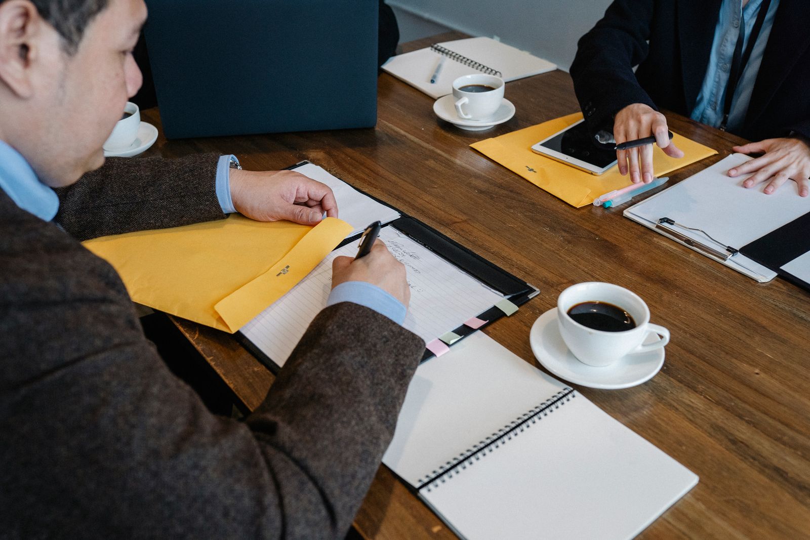 Coffee cups, folders and notebooks on a wooden table in our meeting room