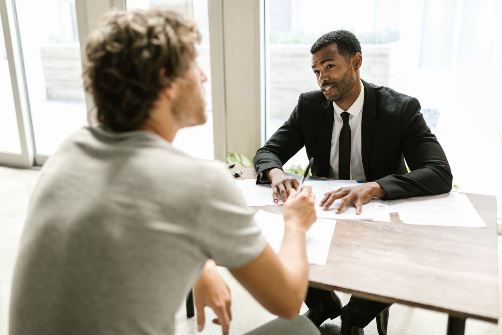 A preparer and a client at a table reviewing printed forms